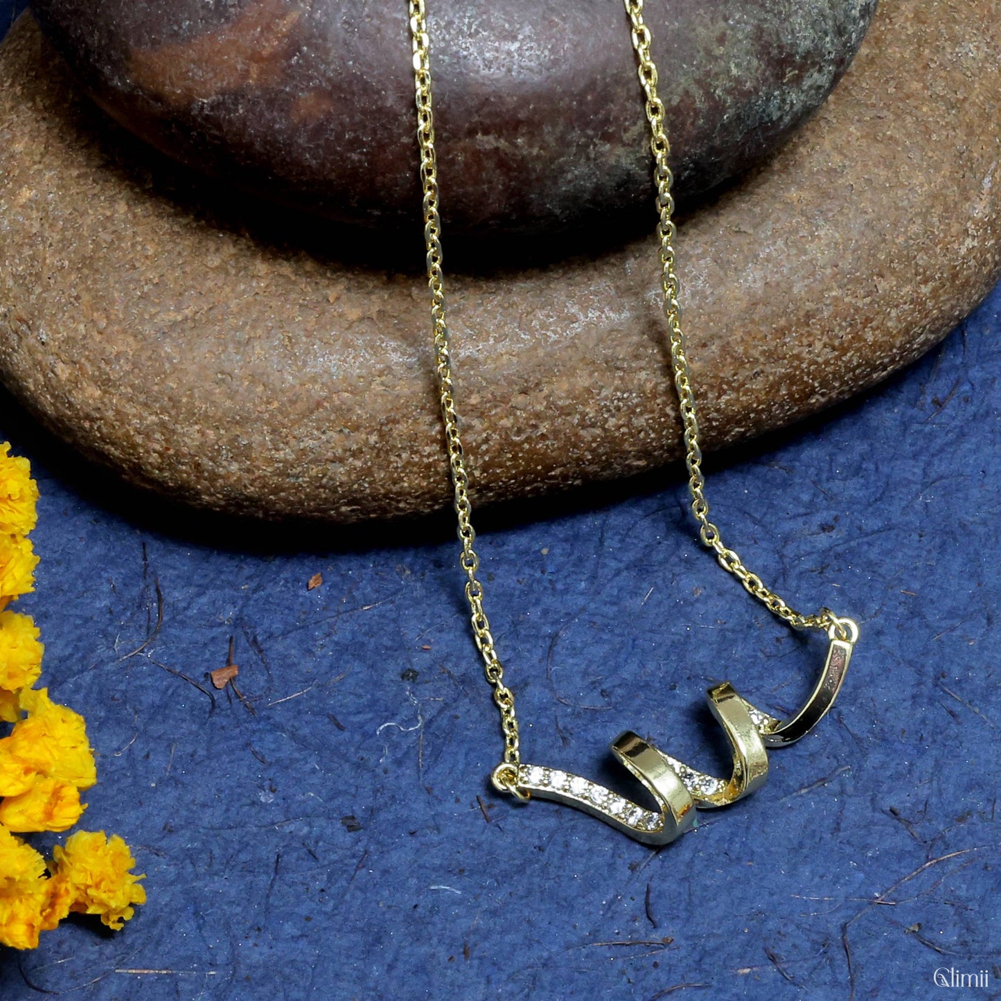 Glimii Korean style jewelry gold necklace with delicate heart-shaped pendant on blue and stone background
