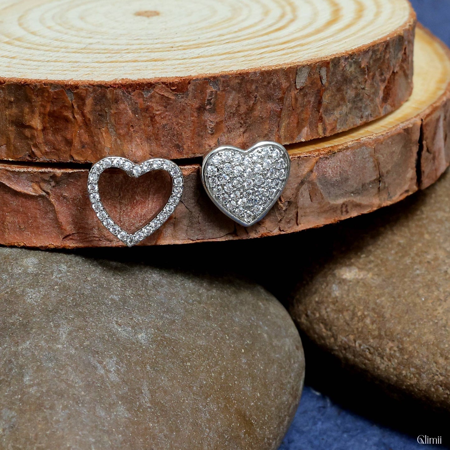 Glimii dainty heart jewelry for women featuring sparkling silver heart-shaped earrings on wood and stone background