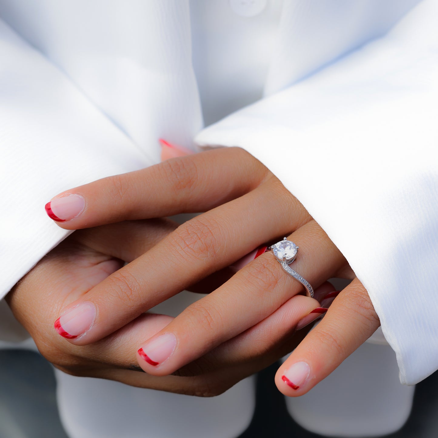 Dainty promise ring for her by Glimii worn on hand with white long sleeve and red tipped nails