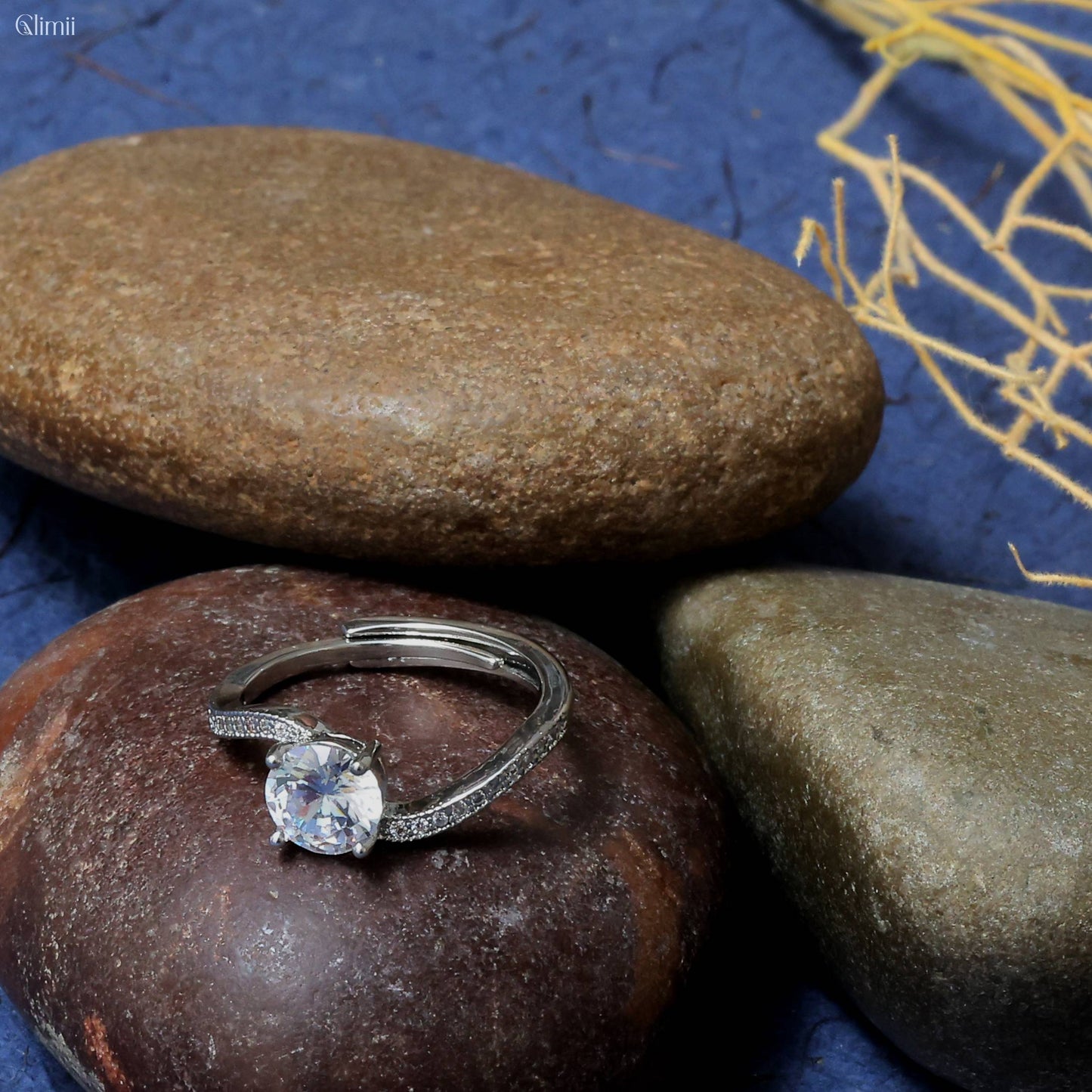 Glimii dainty promise ring for her with a sparkling center stone on smooth natural stones