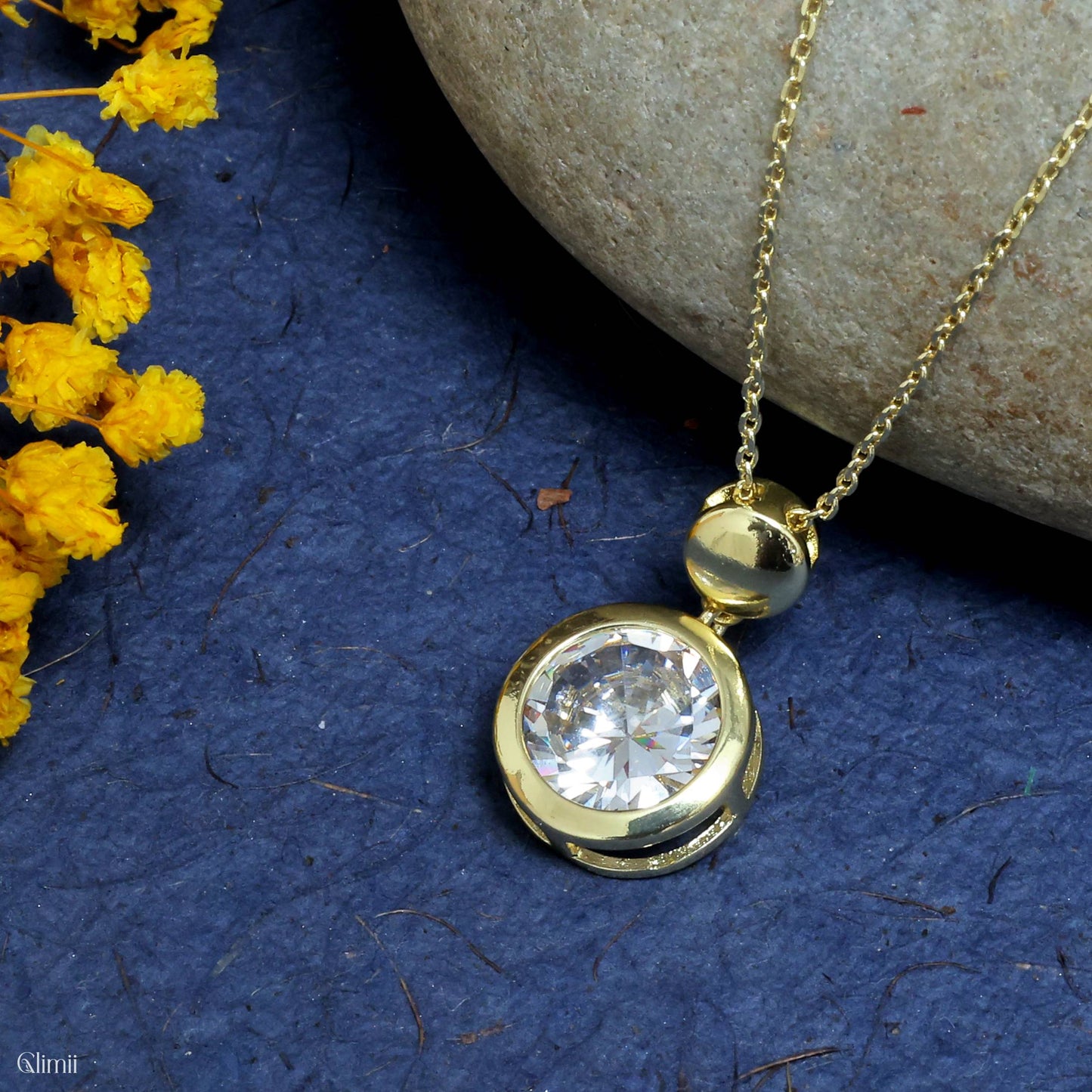 Elegant layering necklace by Glimii featuring a gold chain with a round clear crystal pendant