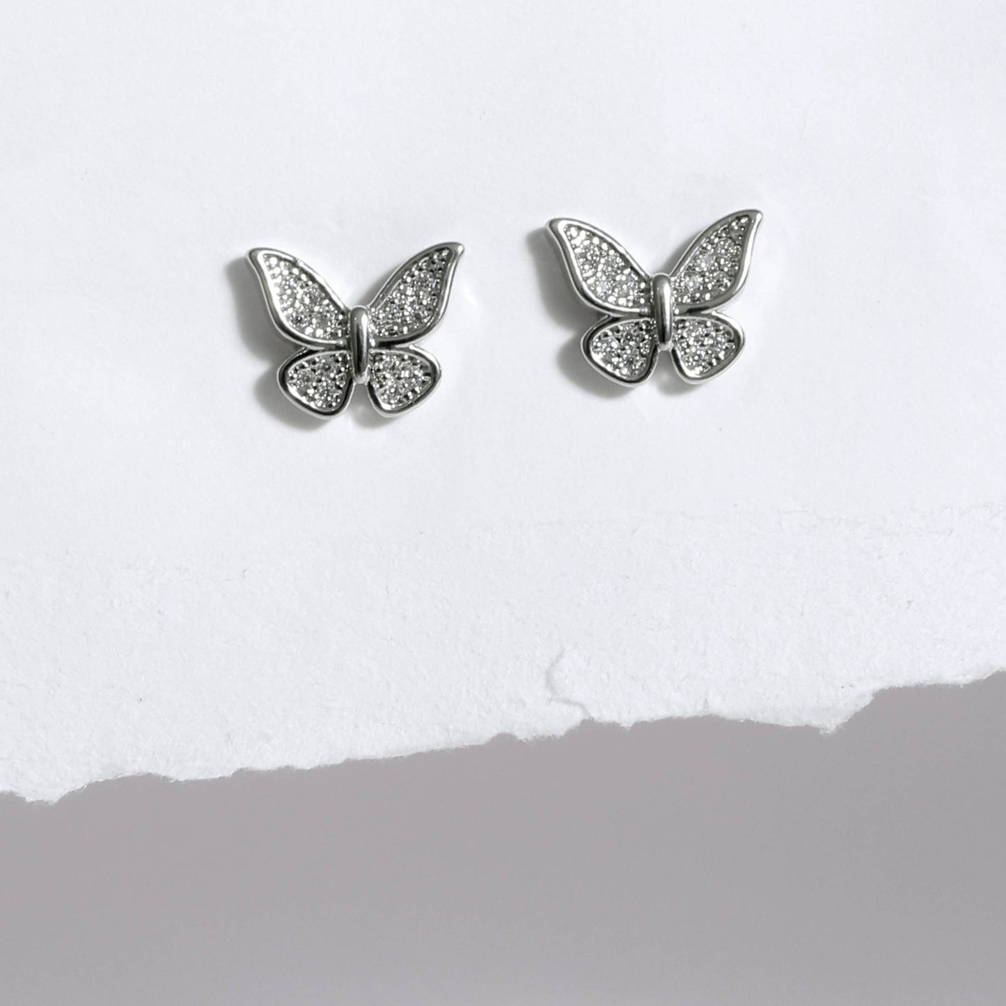 Glimii silver butterfly stud earrings with sparkling crystal details on white background