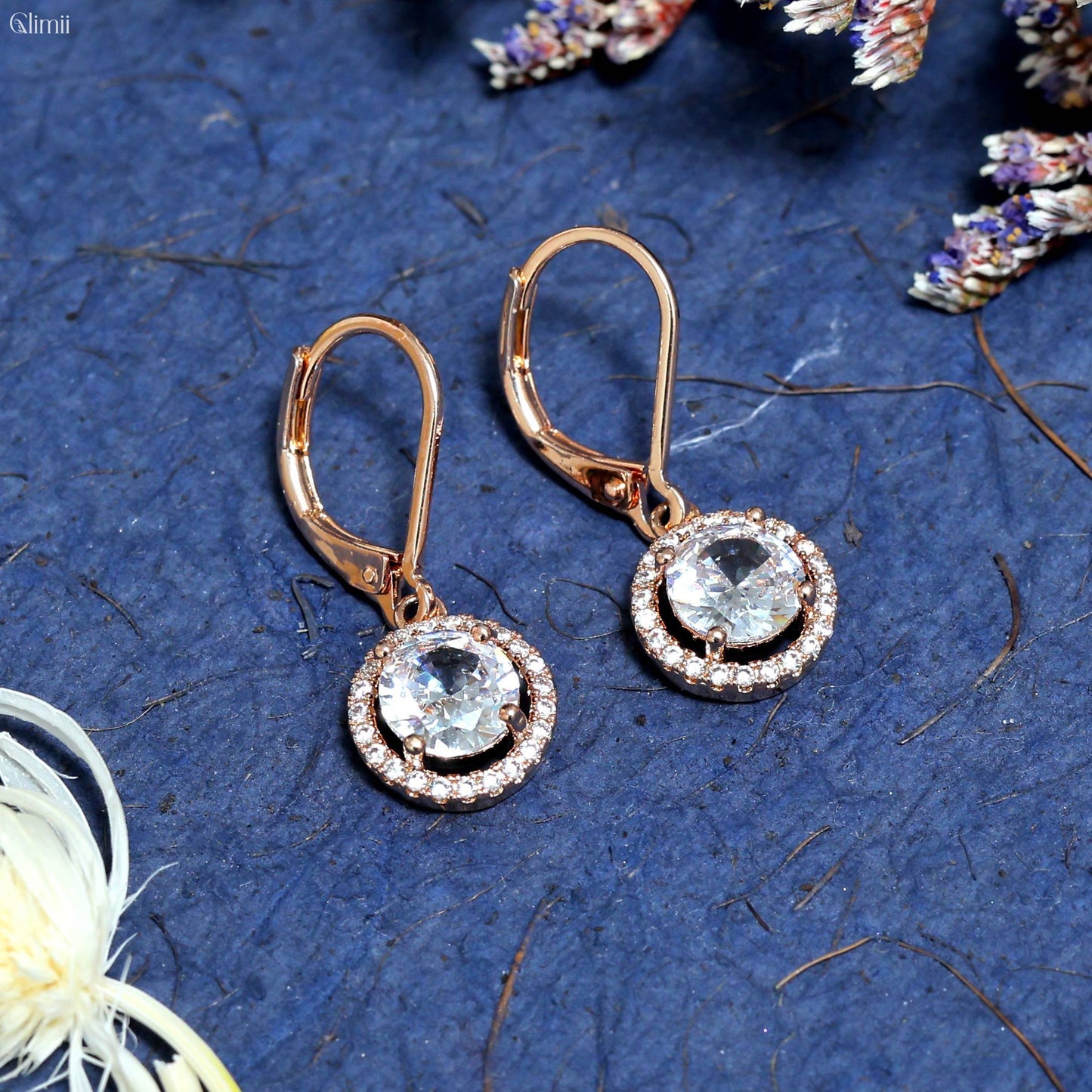 Glimii dainty stainless steel earrings with round clear crystals and rose gold finish on blue background