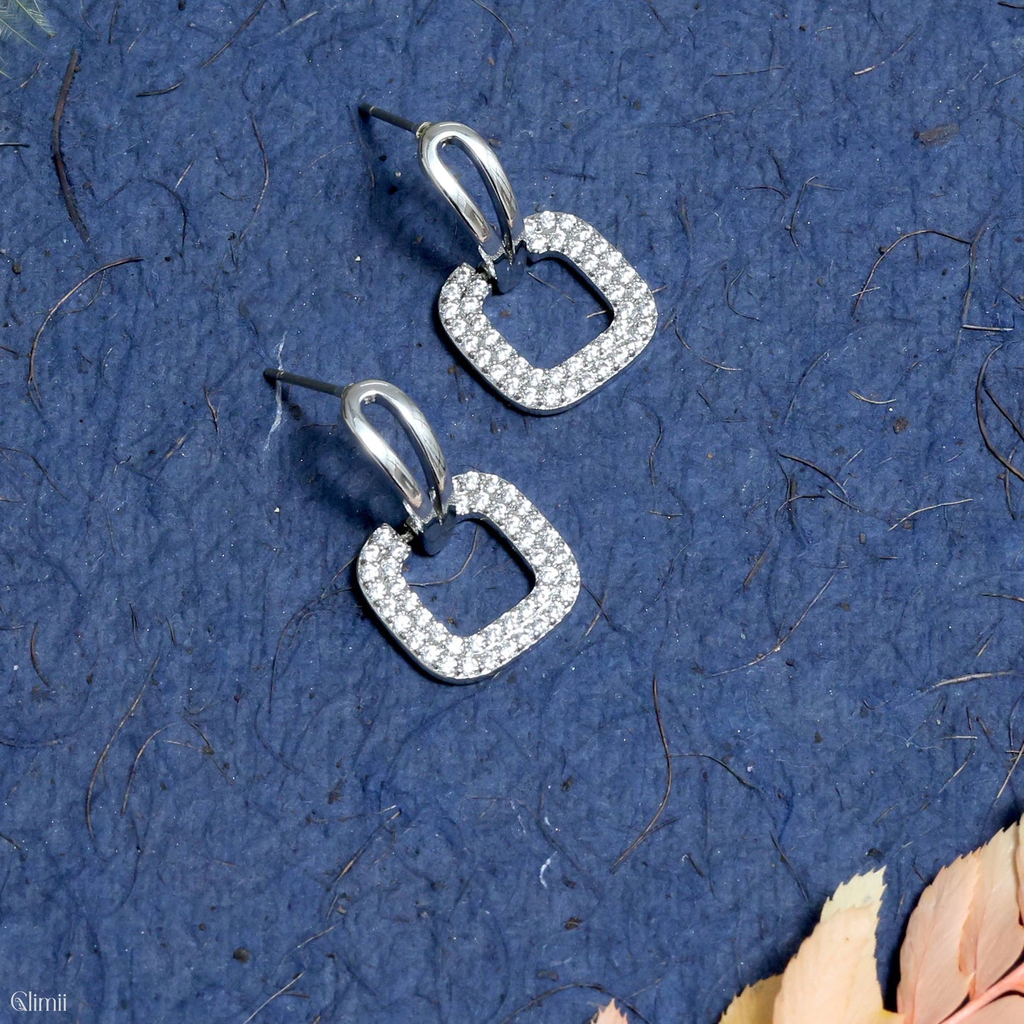 Glimii Korean style hoop earrings with square crystal design on blue textured background