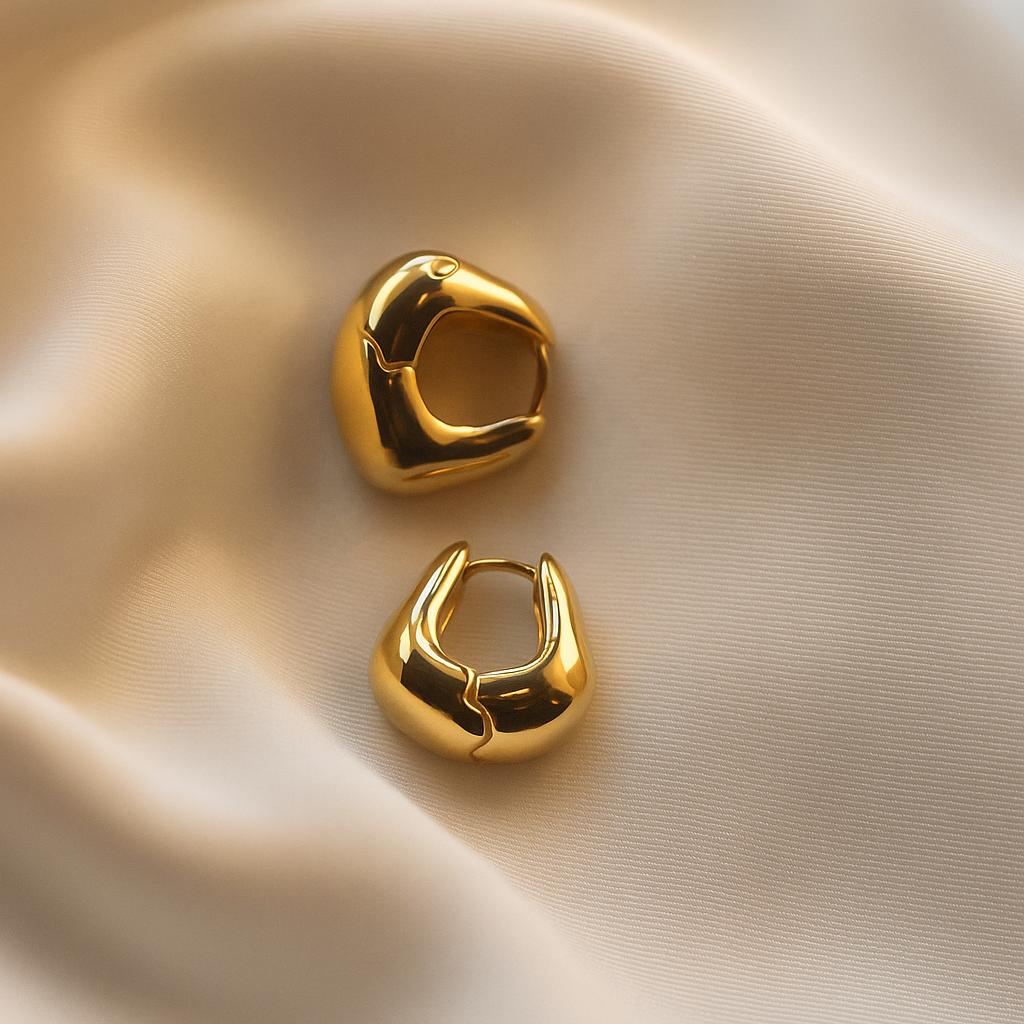 Glimii minimalist gold hoop earrings with smooth polished finish displayed on beige fabric