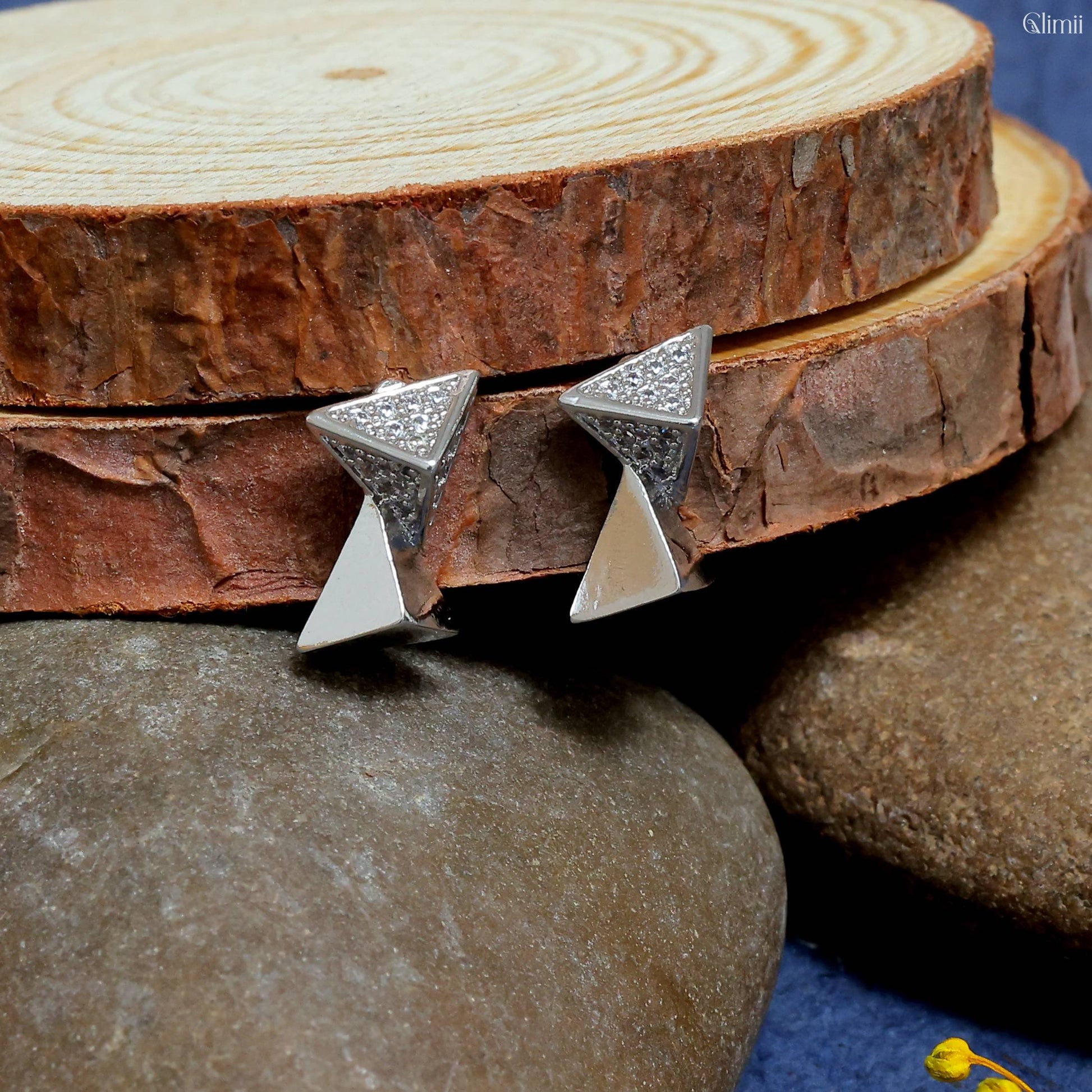 Glimii elegant everyday stud earrings with modern geometric design in silver on natural wooden and stone background