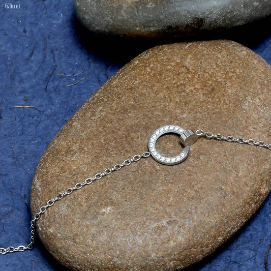 Glimii Korean style circle bracelet with silver chain and crystal-embedded circular charm on stone surface