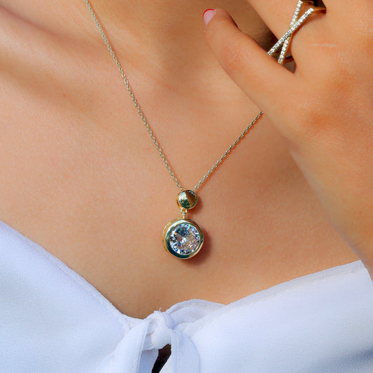 Glimii elegant layering necklace with a round crystal pendant worn with white top and diamond ring