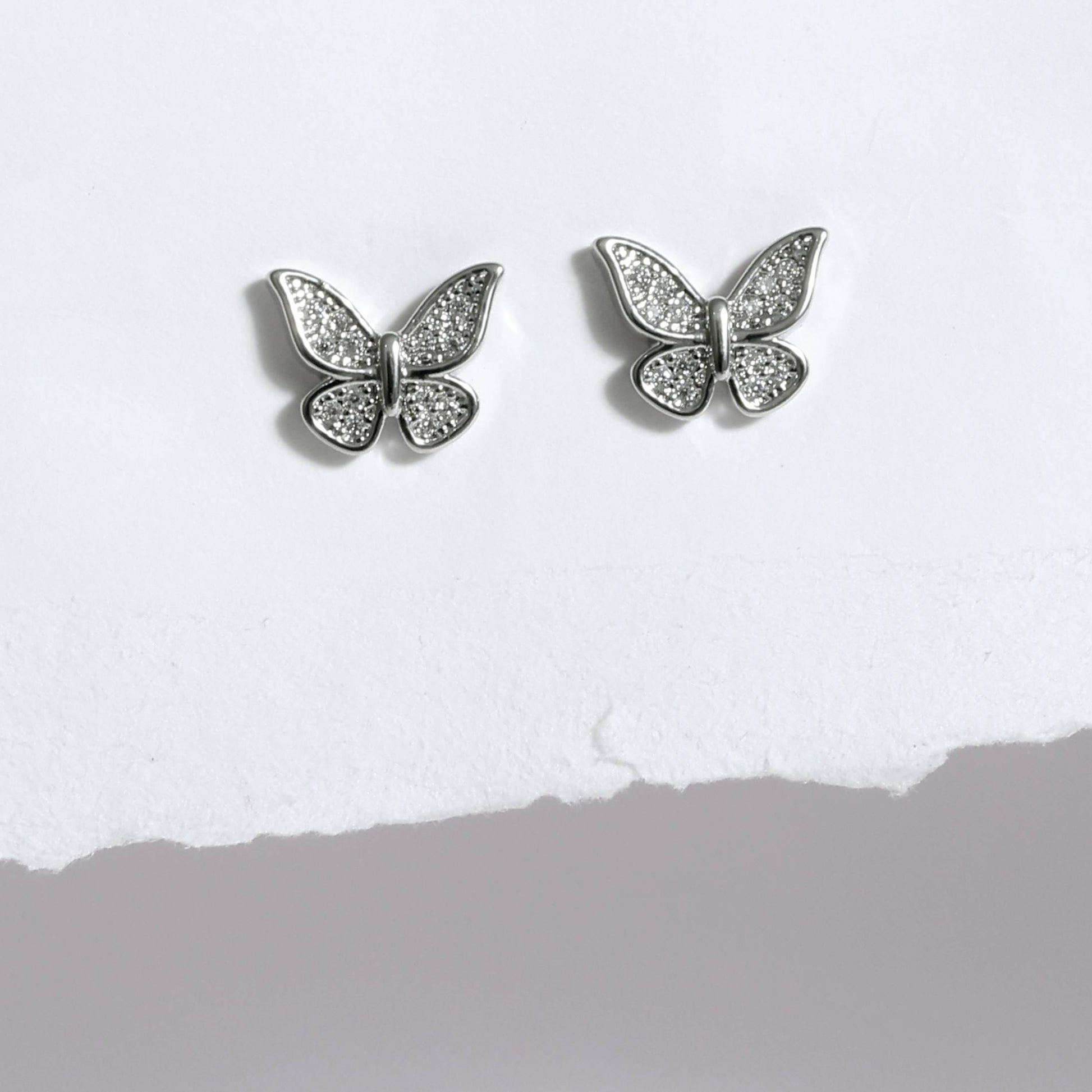 Glimii silver butterfly stud earrings with sparkling crystal details on white background