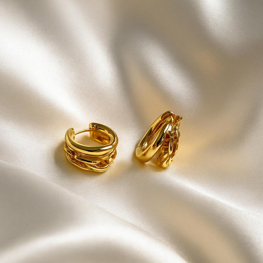 Glimii gold hoop everyday elegant earrings displayed on smooth silk fabric background