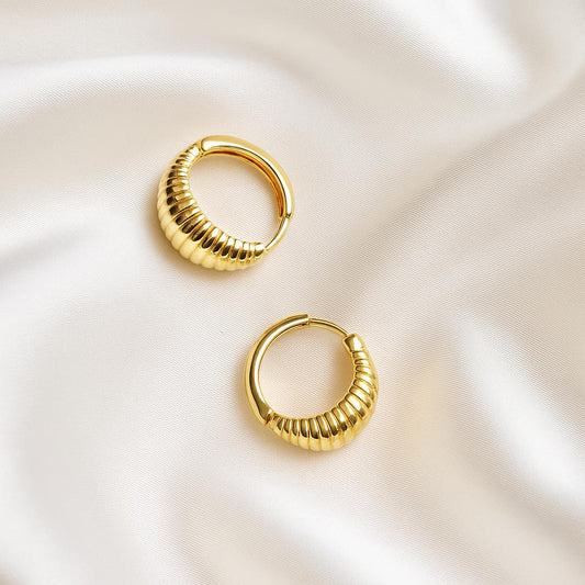 Glimii gold Korean style hoop earrings with ribbed design on white silk background