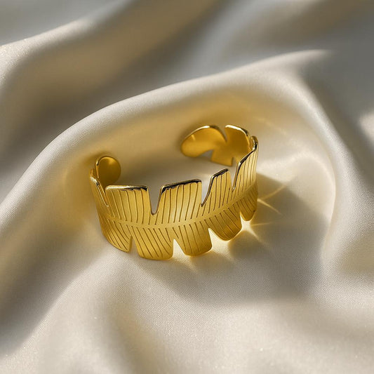 Glimii gold tone Korean style jewelry cuff with leaf design on smooth fabric background