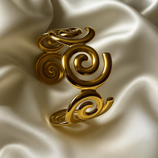 Glimii gold plated statement bracelet with intricate spiral design on satin fabric