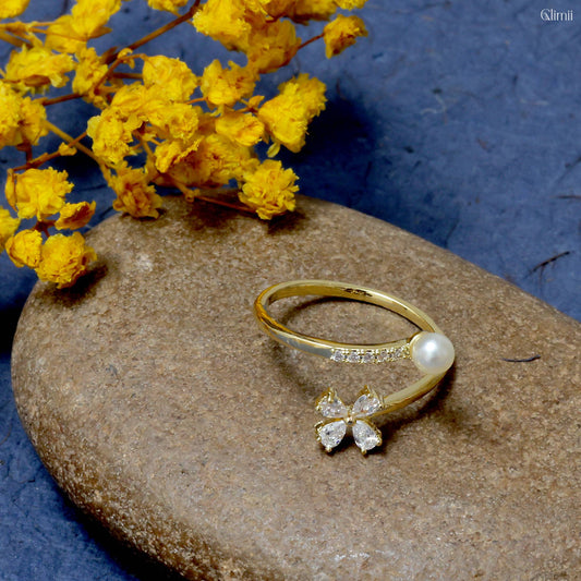 Delicate pearl flower jewelry gold ring with pearl and flower design on stone with yellow flowers