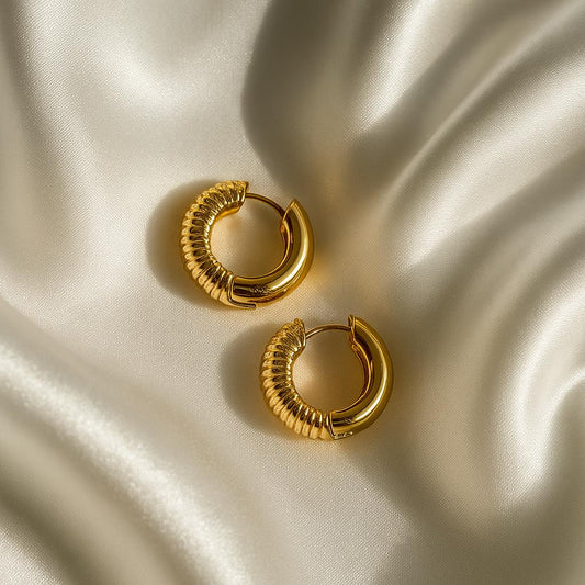Glimii Korean style gold hoops with textured and smooth design on silky fabric background