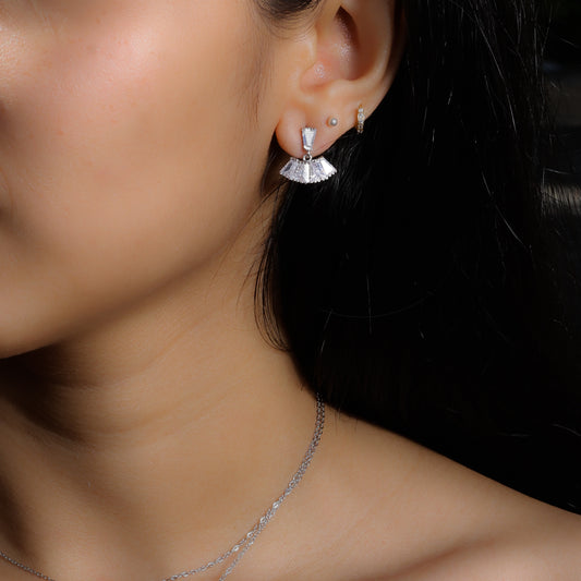 Glimii minimalist stainless steel earrings with fan-shaped design worn on ear with additional small hoop and stud earrings