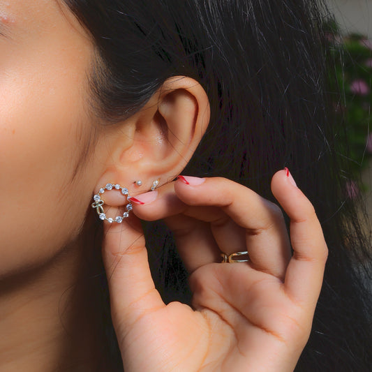 Close-up of a person wearing Glimii stainless steel hoop earrings with decorative stones