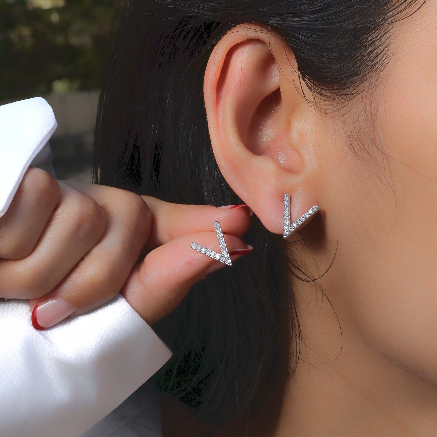 Glimii stainless steel stud earrings in V shape with sparkling stones worn on ear