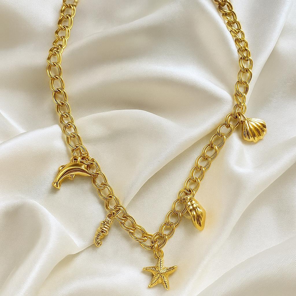 Glimii starfish gold plated necklace with marine-themed charms including starfish, dolphin, shell, and seahorse on gold chain