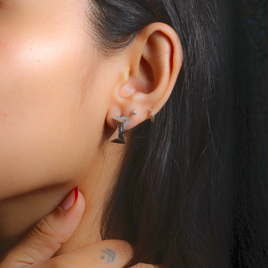 Close-up of elegant everyday stud earrings worn on a woman’s ear by Glimii